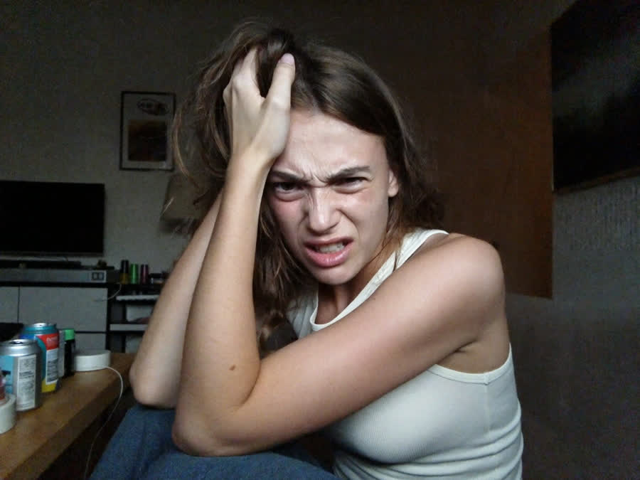 A stressed, wired woman with her hand on her head